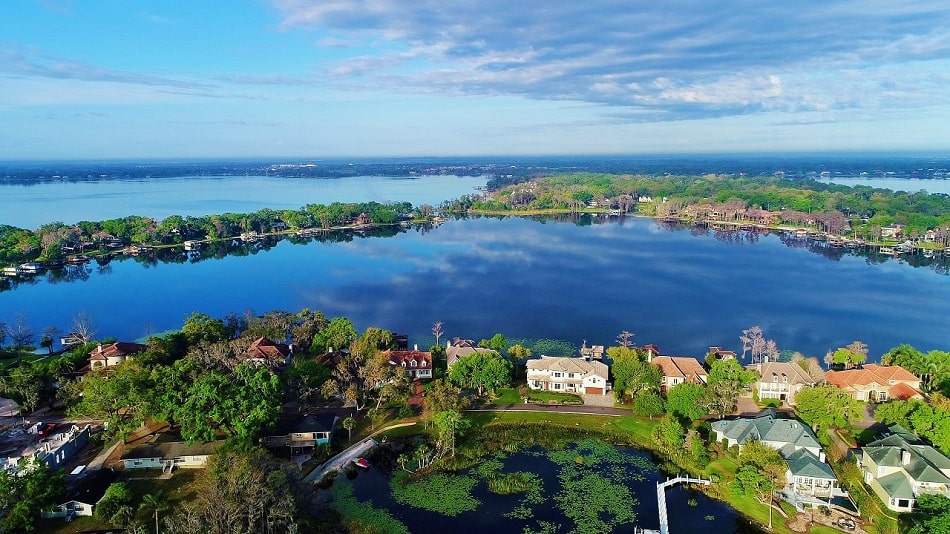 A view of a lake in Windermere, Florida with a town in the background